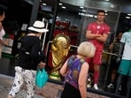 A enlarged replica of the FIFA World Cup trophy is displayed in a shop window next to a mannequin resembling Portugal soccer team captain Cristiano Ronaldo