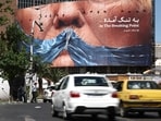 People drive past an anti-U.S. billboard depicting U.S. President Donald Trump and the Strait of Hormuz, in Tehran, Iran, May 26, 2026. 