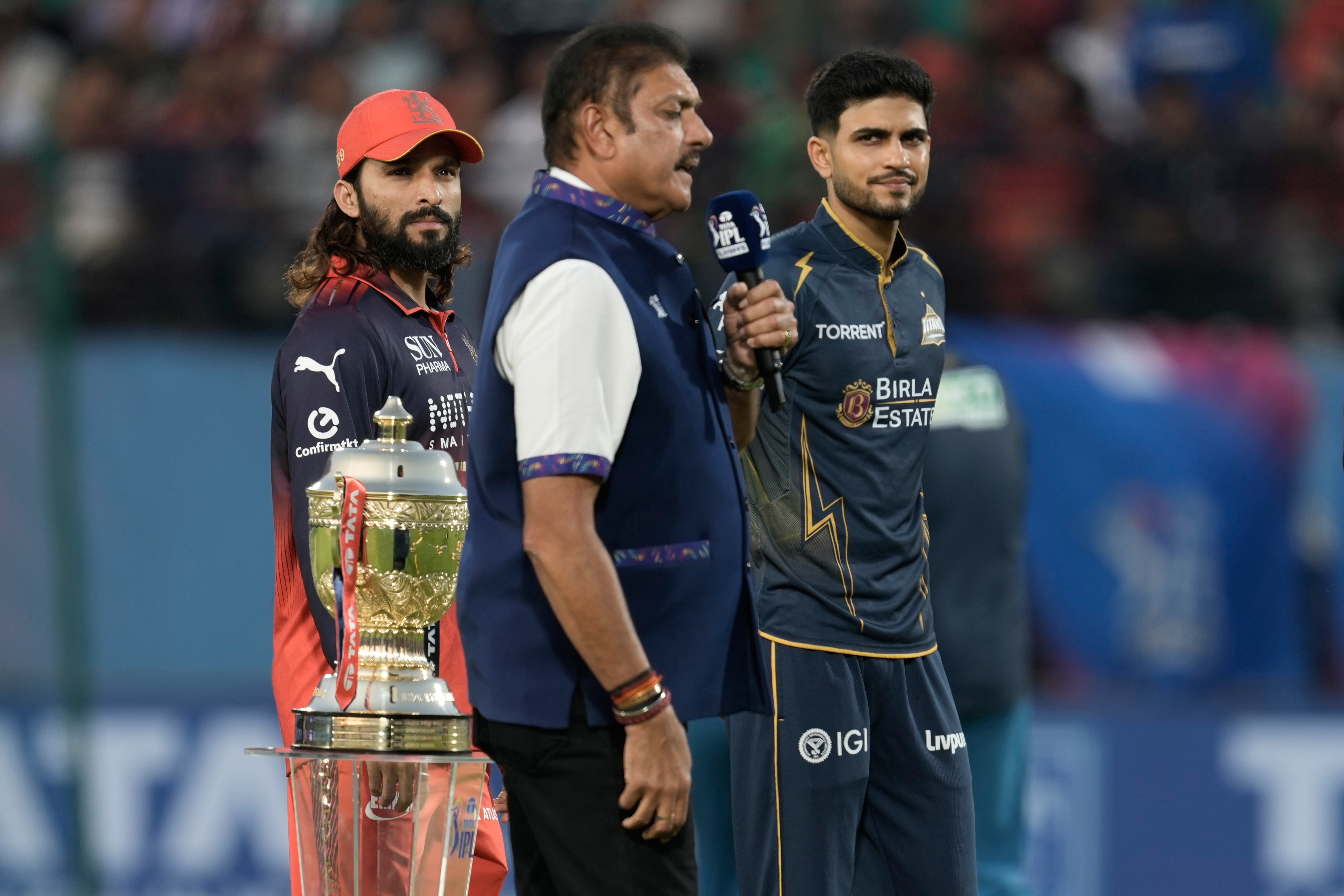 Royal Challengers Bengaluru's captain Rajat Patidar, left, and Gujarat Titans' captain Shubman Gill, right, listen to commentator Ravi Shastri before the coin toss ahead of the Indian Premier League cricket match between Gujarat Titans and Royal Challengers Bengaluru in Dharamshala on May 26, 2026. (AP Photo/Ashwini Bhatia) Royal Challengers Bengaluru's captain Rajat Patidar, left, and Gujarat Titans' captain Shubman Gill, right, listen to commentator Ravi Shastri before the coin toss ahead of the Indian Premier League cricket match between Gujarat Titans and Royal Challengers Bengaluru in Dharamshala on May 26, 2026. (AP Photo/Ashwini Bhatia)