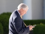 Sen. Lindsey Graham looks at his phone in the Rose Garden before President Donald Trump arrives on Marine One on the South Lawn of the White House. (AP FILE PHOTO)