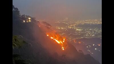 The forest fire on the slopes of the Kasauli hills on Tuesday night. The Chandigarh tricity lights are visible in the backdrop. (HT Photo) The forest fire on the slopes of the Kasauli hills on Tuesday night. The Chandigarh tricity lights are visible in the backdrop. (HT Photo)