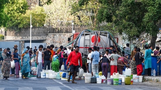 Residents of Vivekanand Camp in Delhi's Chanakyapuri fill empty vessels from a water tank on a hot summer afternoon on May 26. (Vipin Kumar/ HT Photo)
