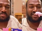 A man is seen happily enjoying a family pack of ice cream.