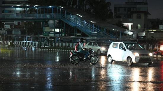 Commuters navigate through light rain at Rajiv Chowk near Mini Secretariat on Thursday. (Parveen Kumar/HT PHOTO)