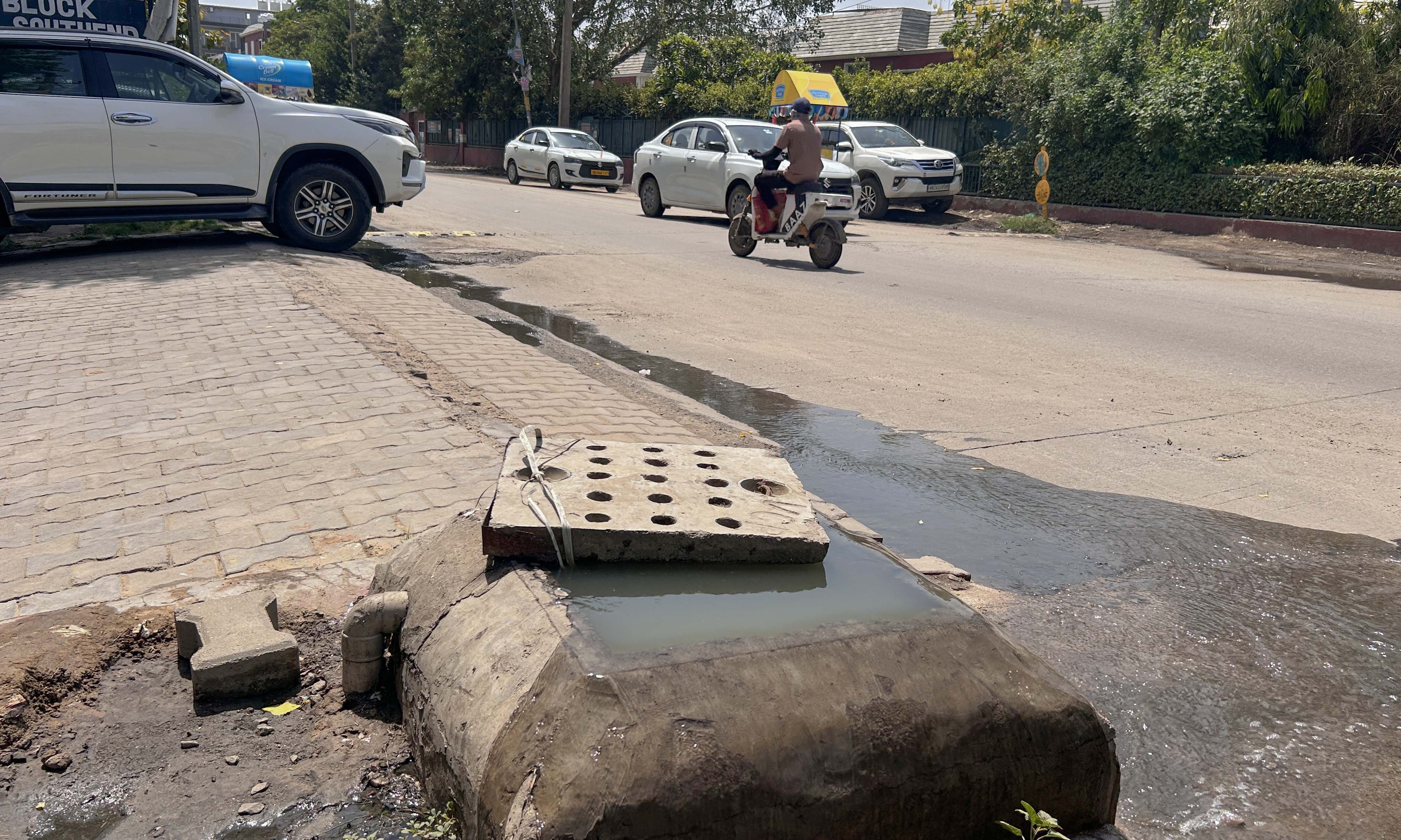 Overflowing sewage from a manhole near Scottish Castle P Block in Sector 48 on Wednesday. (Parveen Kumar/HT)
