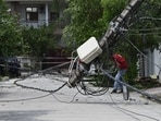 A man passes a damaged electric pole after a late-night storm in Lucknow on Friday. (Deepak Gupta/HT Photo)