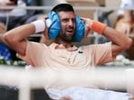 Serbia's Novak Djokovic reacts while sitting in between games as he plays against Brazil's Joao Fonseca 
