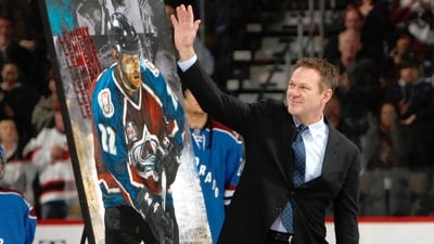 Retired Colorado Avalanche player Claude Lemieux waves to fans as he is honored (AP Photo/David Zalubowski)