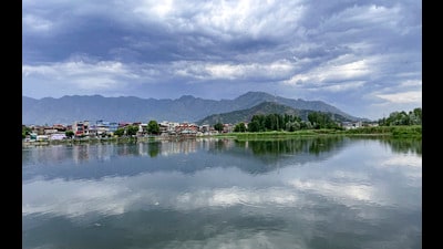 Dark clouds hover over Babadem lake and residential houses, in Srinagar, on Friday. (PTI)
