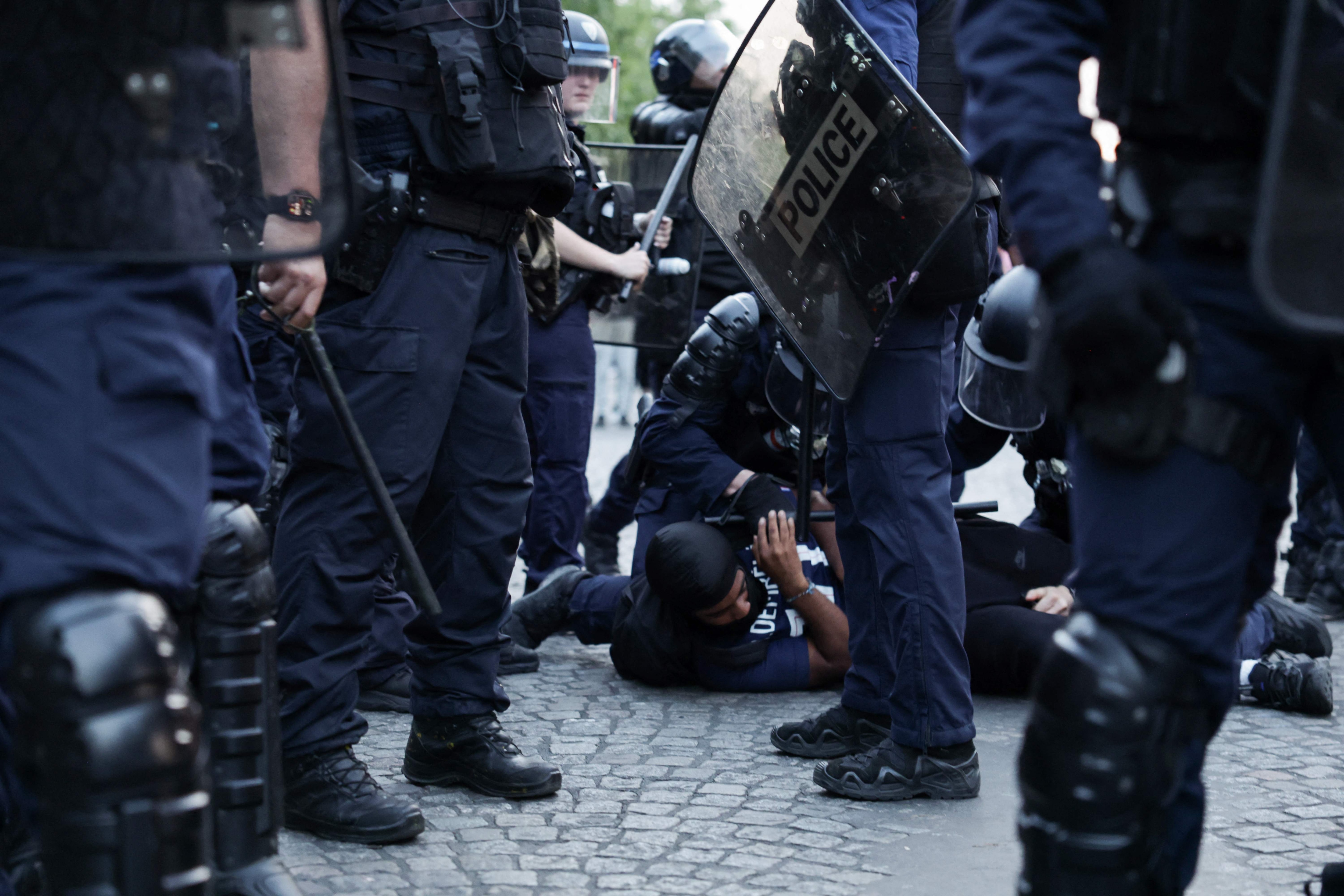 Police officers detain a PSG supporter during celebrations following their team's win in the UEFA Champions League final between Paris Saint-Germain (PSG) and Arsenal FC played in Budapest. (AFP)