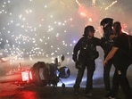 Police try to disperse PSG supporters who left off fireworks as they celebrate in Paris.