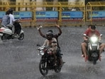 Passengers make their way through the city during a sudden spell of rain in Lucknow on Sunday (Deepak Gupta/ht)