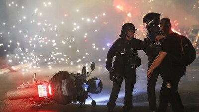 Police try to disperse PSG supporters who left off fireworks as they celebrate in Paris. (AP Photo/Thomas Padilla) Police try to disperse PSG supporters who left off fireworks as they celebrate in Paris. (AP Photo/Thomas Padilla)