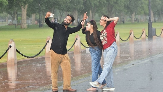 Delhiites made the most of the pleasant weather after fresh spells of rain, over the weekend, cooled down the temperatures in the city. As mercury is expected to rise again and hover around 35°C this week, here's how some cheerful moments will help beat the Monday blues. This duo at India Gate makes the most of the rains at the India Gate, Kartavya Path. (Photo: HT)