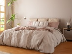 Layered bedding, warm lighting and thoughtful décor details come together to create a cosy bedroom.(Canva.com)