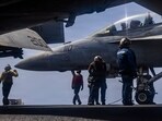 US Sailors prepare to taxi an F/A-18F Super Hornet, attached to Strike Fighter Squadron (VFA) 41, on the flight deck of Nimitz-class aircraft carrier USS Abraham Lincoln.