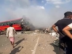 People gather at the site as smoke billows out from a bus following a road accident involving two buses on the Gujarat-Maharashtra Highway.
