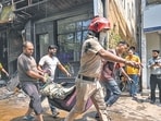 Firefighters and local residents during rescue operations in Wednesday. (Sanchit Khanna/Hindustan Times)