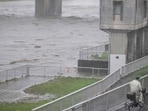 A man cycles past the Tama river amid heavy rain brought by severe tropical storm Jangmi in Tokyo on June 3, 2026.