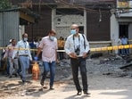 Forensic officials leave the site of a fire at a hotel in the Malviya Nagar area, in New Delhi. (PTI Photo/Karma Bhutia)