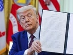 US President Donald Trump displays a signed executive order in the Oval Office of the White House.