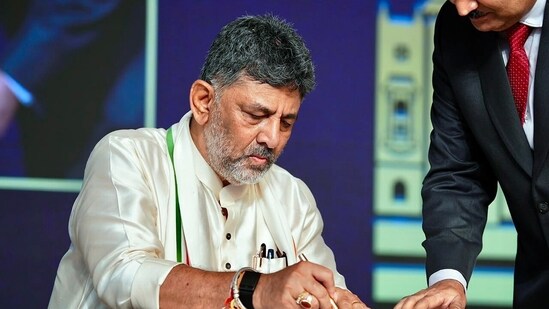 Karnataka CM-designate DK Shivakumar signs a document as he takes the oath as Chief Minister of Karnataka during the swearing-in ceremony, in Bengaluru. (X/@DKShivakumar)