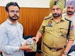 A policeman returns cash to a victim in Ludhiana on Thursday. (HT PHOTO)