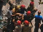 Firefighters rescue a foreign national from the hotel fire. (AP)