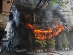 Local people attempt to douse a fire at a hotel in Delhi's Malviya Nagar on Wednesday