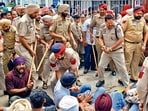 Police personnel use force to remove the protesters from the gate of PSPCL headquarters in Patiala on Friday. (PTI)