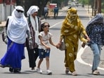 Commuters cover their faces and heads to protect from the sweltering sun (Anil Kumar Maurya/HT)
