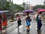 People cover themselves and cross a road during rainfall as monsoon arrives, in Kochi, Kerala, Friday, June 5, 2026. Heavy rains continued to lash several parts of Kerala, waterlogging roads and flooding low-lying areas, with the IMD on Friday issuing an orange alert in seven districts of the state.