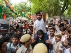 A supporter carries the Cockroach Janta Party (CJP) founder Abhijeet Dipke, in white, over his shoulder during a protest demanding the resignation of Union Education Minister Dharmendra Pradhan over alleged examination-related lapses, at the Jantar Mantar, in New Delhi, Saturday, June 6, 2026. 