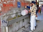 Passengers fill water from a tap at the facility at the ISBT in Ludhiana on Sunday. (Gupreet Singh/HT)