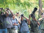 Bird enthusiasts observe the grey and oriental pied hornbill at the Lodhi Garden on Saturday. (Sanchit Khanna/HT Photo)