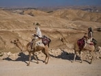 Israeli settler parents travel with their baby on camels in the northern Judean Desert near the settlement of Maale Adumim, in the West Bank, Thursday.