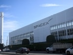 Vehicles drive past a SpaceX Falcon 9 rocket displayed outside a Space Exploration Technologies Corp. facility in Hawthorne, California.