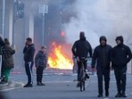 Northern Ireland police appealed for calm Tuesday after a stabbing in Belfast allegedly by a Sudanese suspect, while fire is seen amid protests there. 