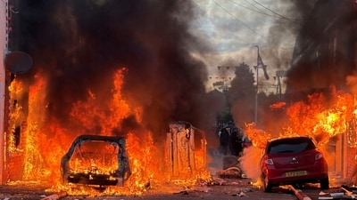 Vehicles set on fire by protesters burn on Lendrick Street in east Belfast, Northern Ireland, on Tuesday, June 9, 2026, after the arrest of a Sudanese man accused of stabbing a man in the northern part of the city. (PA via AP)