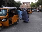 Afghan women wearing chador walk along the street near the Grand Mosque in Herat.