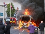 People watch as a vehicle burns during a protest in East Belfast following a stabbing incident in Belfast.