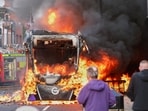 People watch as firemen arrive to put out vehicle that was set alight during a protest in East Belfast following a stabbing incident in Belfast on Tuesday, June 9, 2026.
