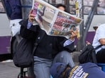A shoeshiner attends a client that reads the front page of a newspaper with a headline that says in Spanish: "Anyone can win!" in Lima, Peru, Tuesday, June 9, 2026, two days after the presidential election runoff.