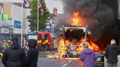 People watch as a vehicle burns during a protest in East Belfast following a stabbing incident in Belfast. (AP Photo)