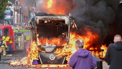 People watch as firemen arrive to put out vehicle that was set alight during a protest in East Belfast following a stabbing incident in Belfast on Tuesday, June 9, 2026. (AP Photo) People watch as firemen arrive to put out vehicle that was set alight during a protest in East Belfast following a stabbing incident in Belfast on Tuesday, June 9, 2026. (AP Photo)