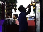 A person consumes alcohol outside a liquor shop in Gurugram. (Yogendra Kumar/HT File)