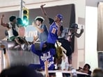 New York Knicks fans climb on a truck as they celebrate outside Madison Square Garden after their team's Game 4 victory over the San Antonio Spurs in the NBA Finals in New York on June 10, 2026. 