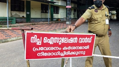 A security guard installs a warning board outside Nipah isolation ward at Government Medical College Hospital, in Kozhikode district. (PTI) A security guard installs a warning board outside Nipah isolation ward at Government Medical College Hospital, in Kozhikode district. (PTI)