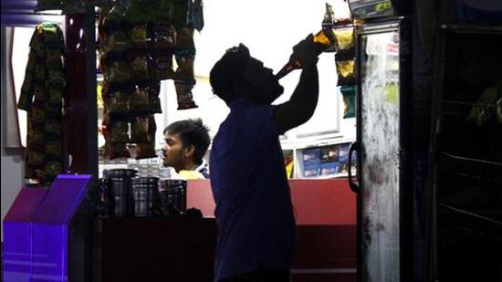 A person consumes alcohol outside a liquor shop in Gurugram. (Yogendra Kumar/HT File)