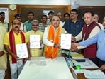 BJP candidates Rajneesh Agrawal, Tarun Chugh and Mahesh Kewat display their certificates of election as they receive them from the Returning Officer, having been declared elected unopposed to the Rajya Sabha from Madhya Pradesh. 